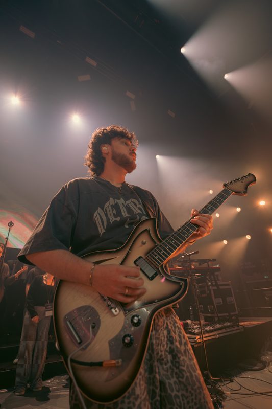 Gitarrist mit E-Gitarre unter Scheinwerfern
