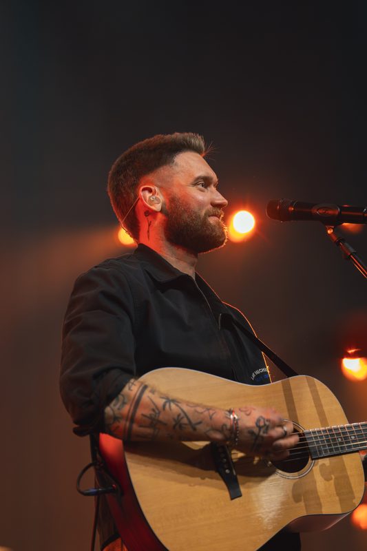 Sänger mit Gitarre im Gegenlicht