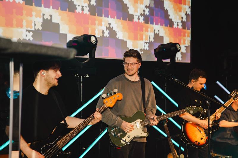 Band auf der Bühne vor bunter Leinwand in Köln
