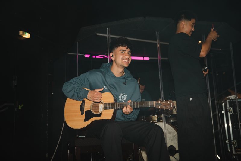 Gitarrist mit Akustikgitarre auf der Bühne